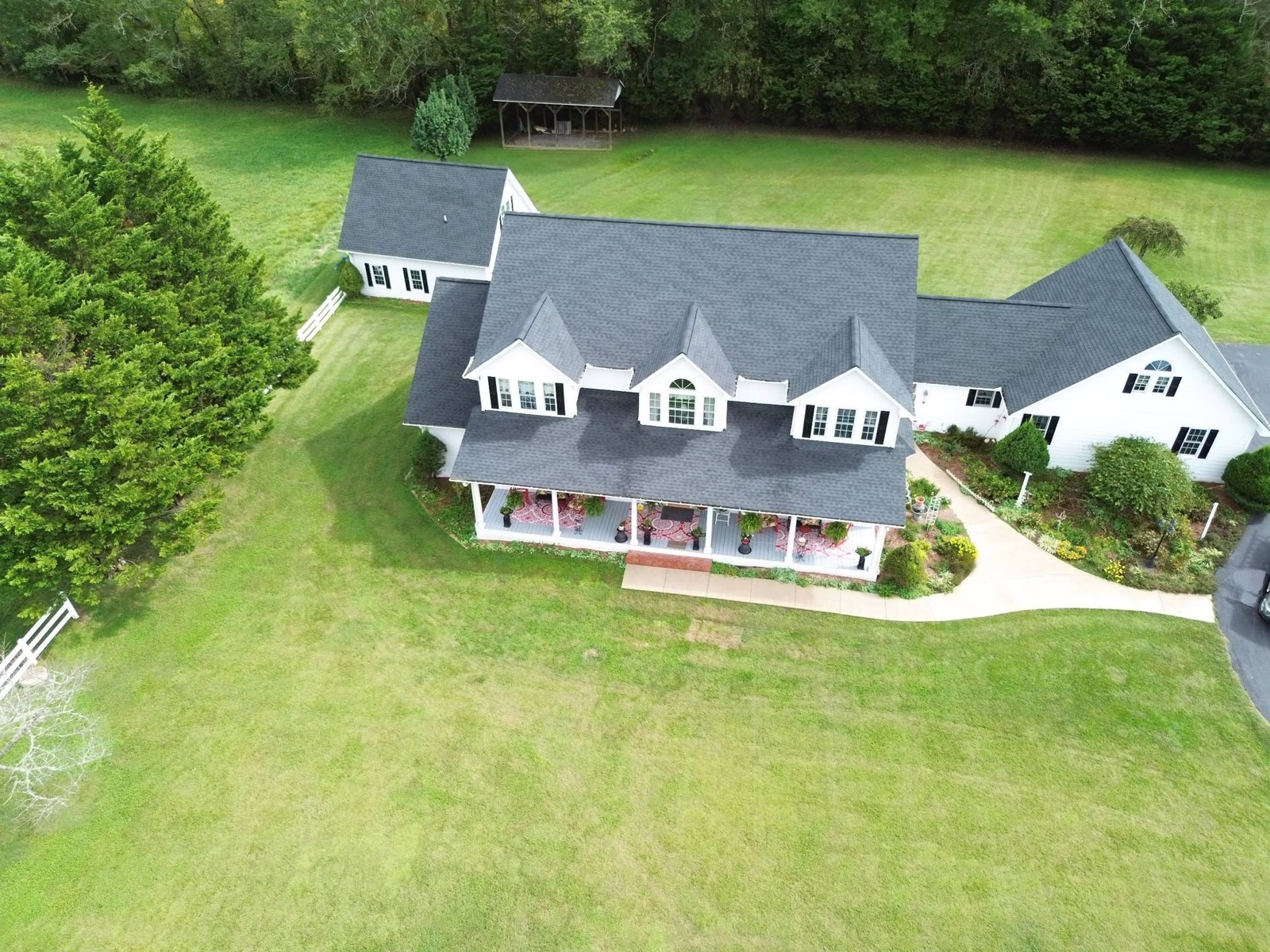 White farmhouse with new dark shingle roof